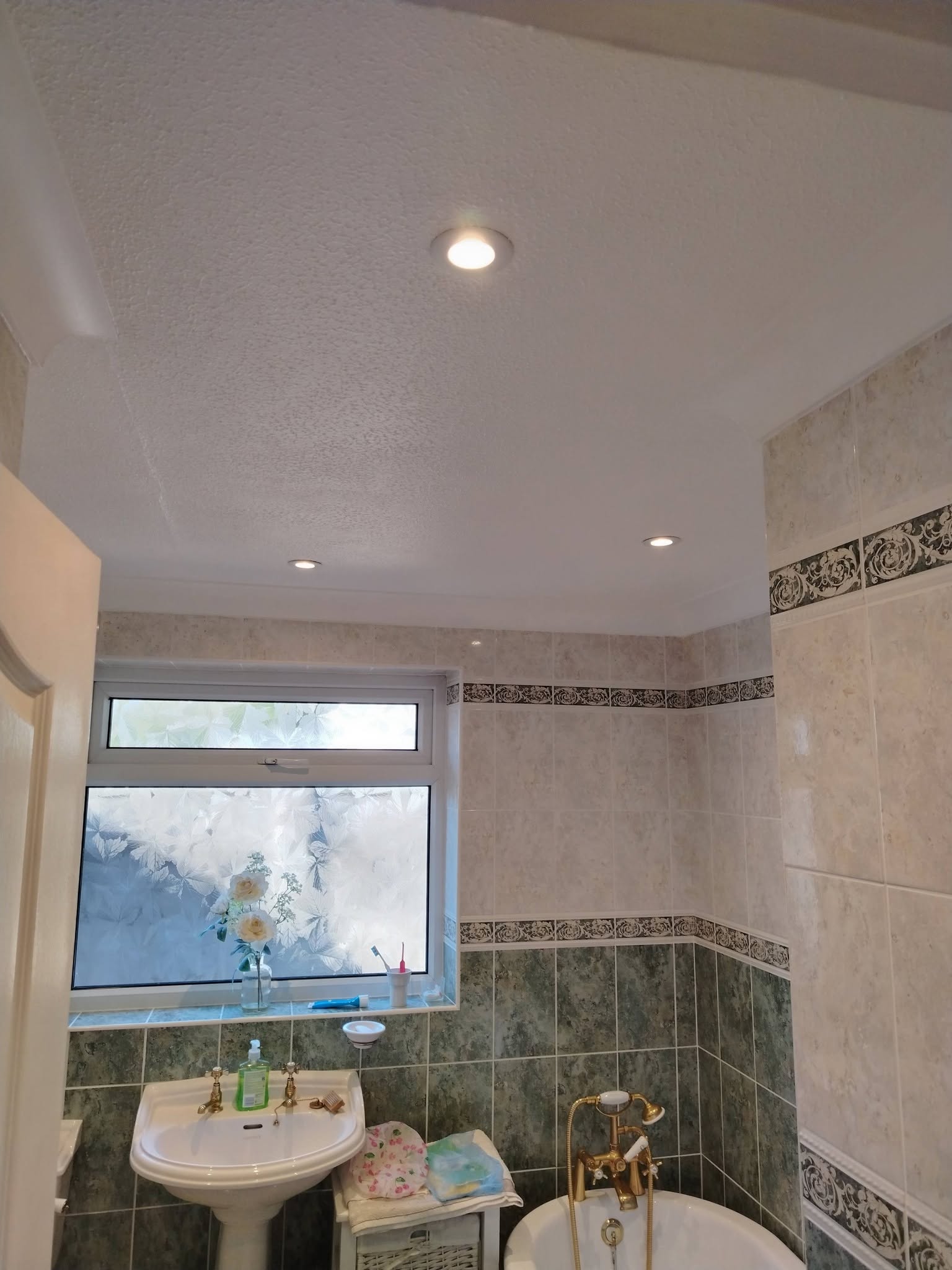 The bathroom with its freshly painted white ceiling