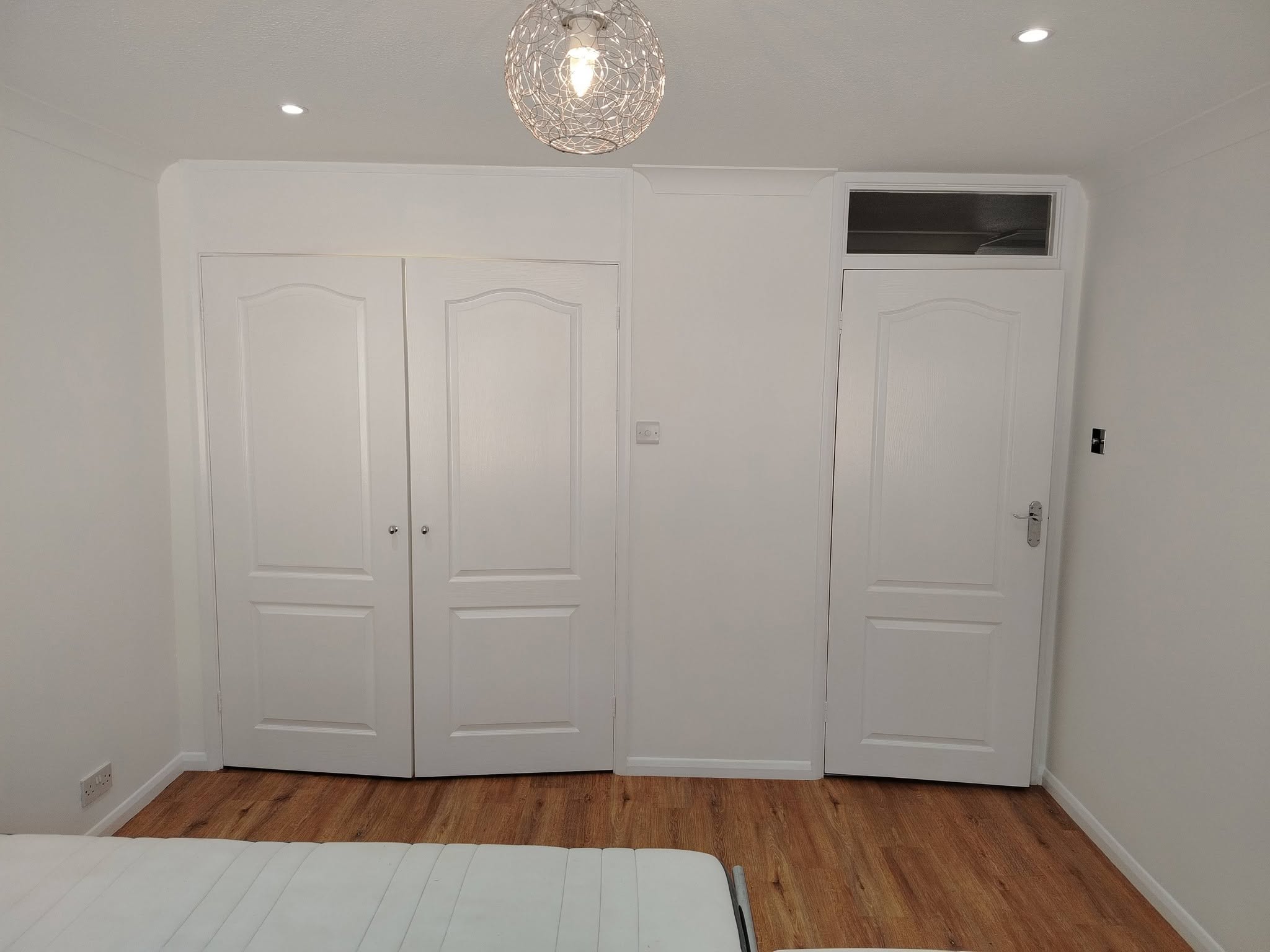 The wardrobe wall after: white walls and white wardrobe doors