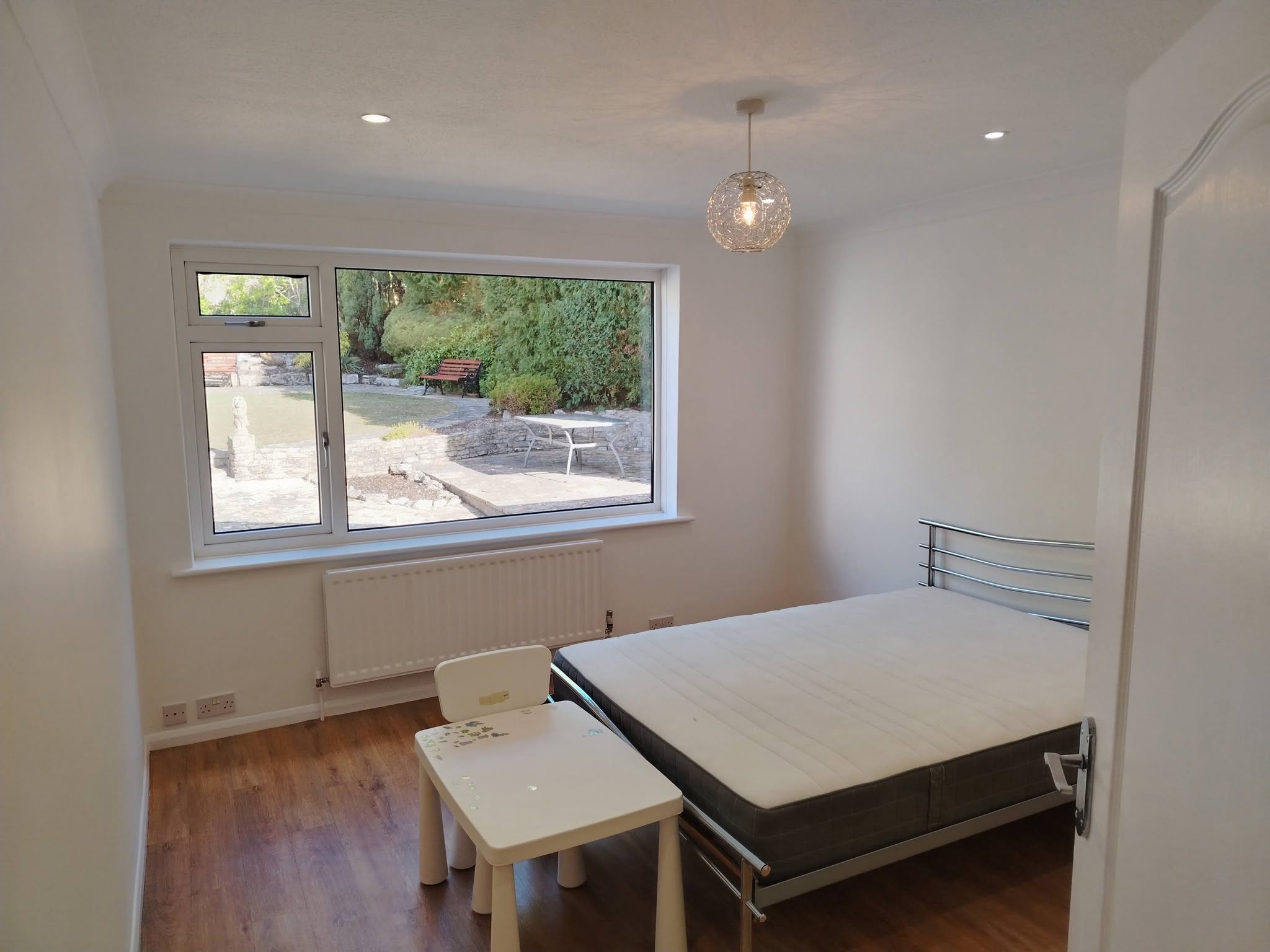The finished white bedroom with a garden window