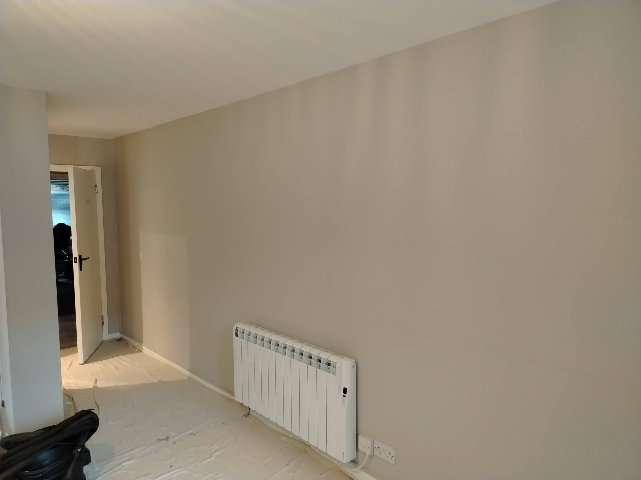 Pale grey walls with the floor still under dust sheets