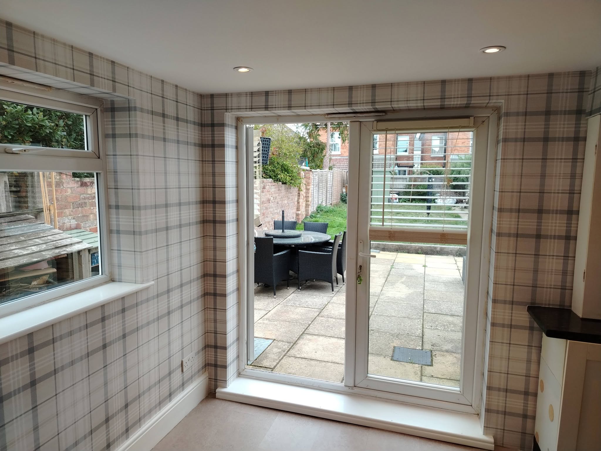 Tartan-papered room with French doors to a patio