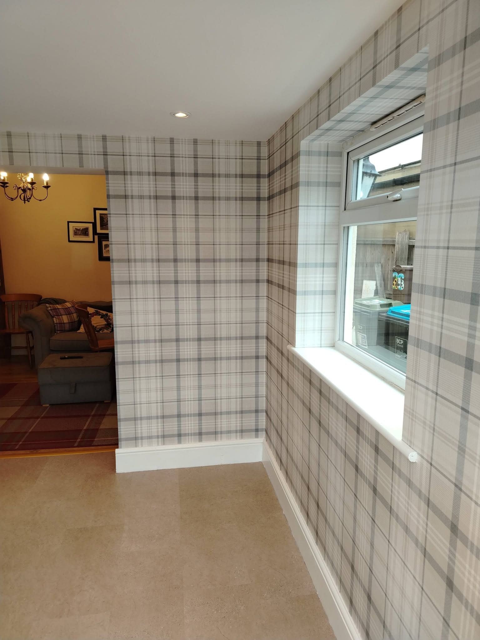 Grey tartan wallpaper around a window and doorway