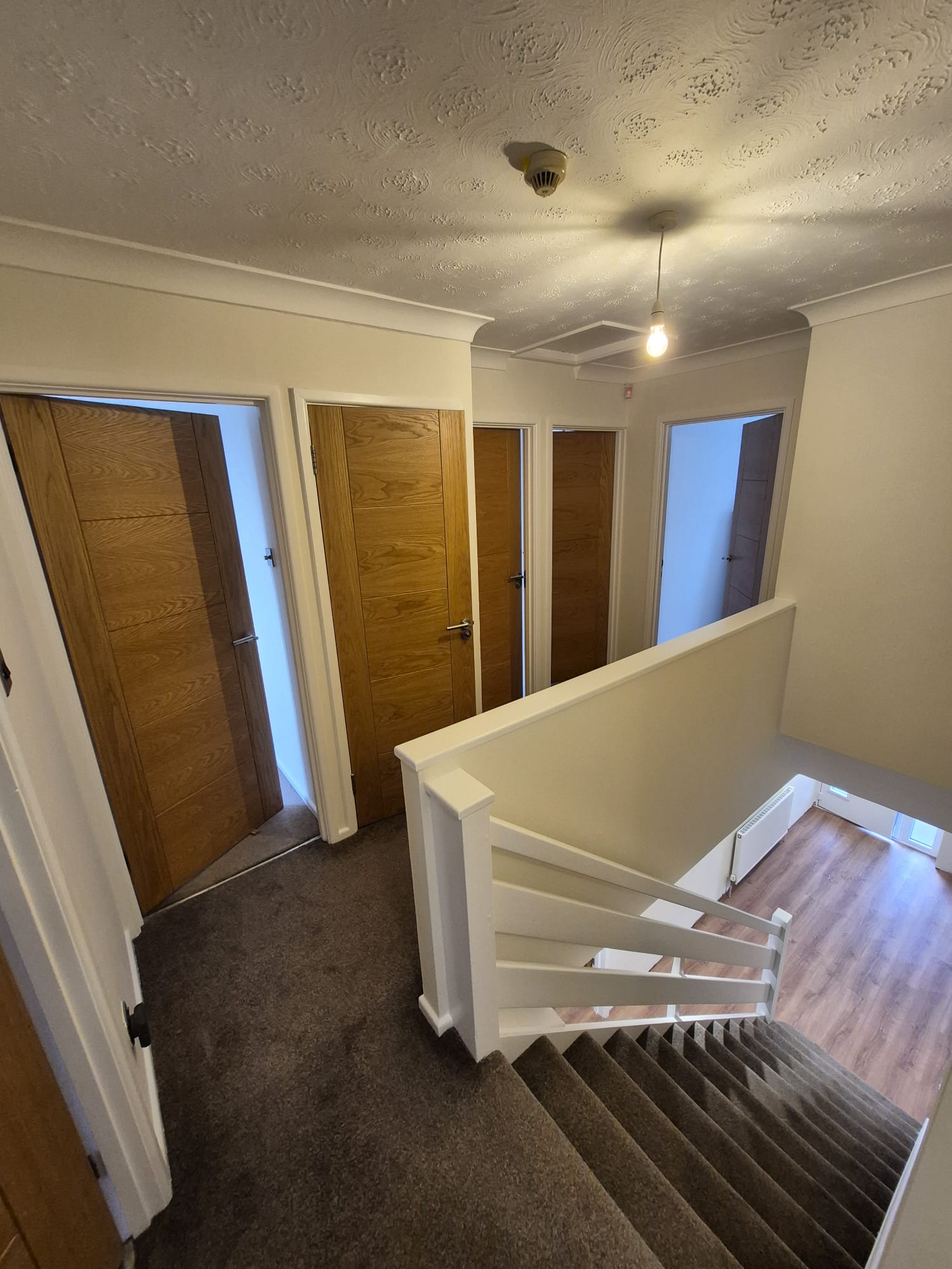 Landing with oak doors and a white banister
