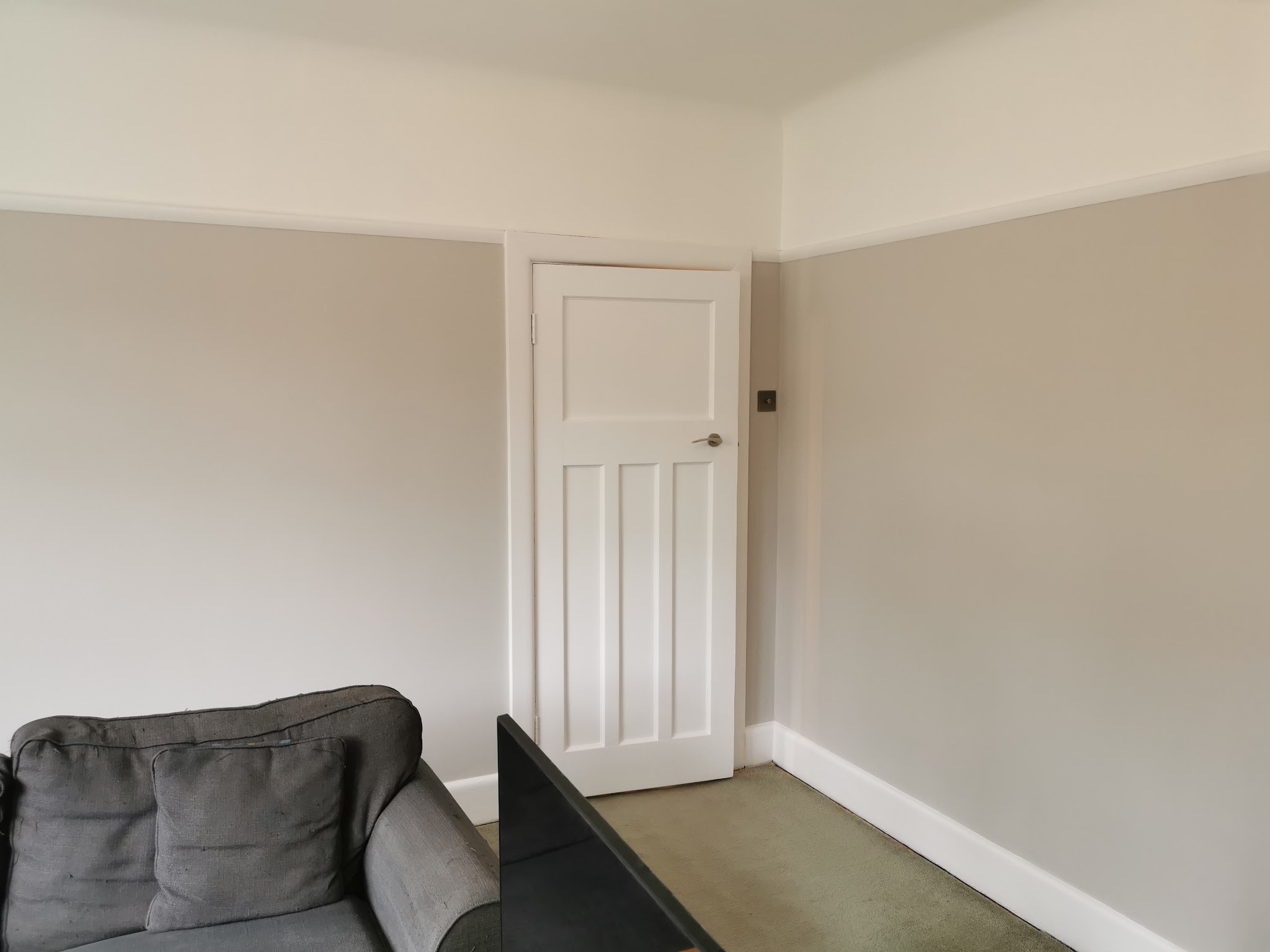 Neutral room with a crisp white panelled door and skirting